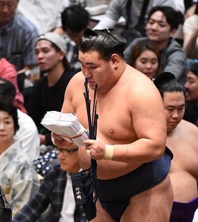 両手で懸賞金の束を持つ豊昇龍＝両国国技館（撮影・園田高夫）