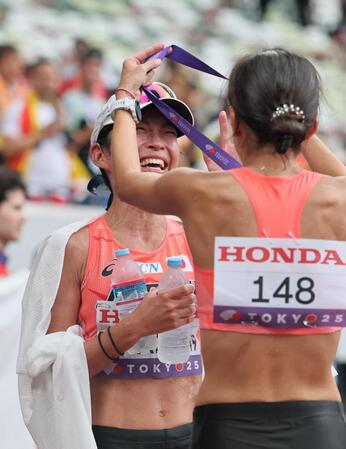 　レース後、藤井菜々子（右）に銅メダルをかけてもらう岡田久美子