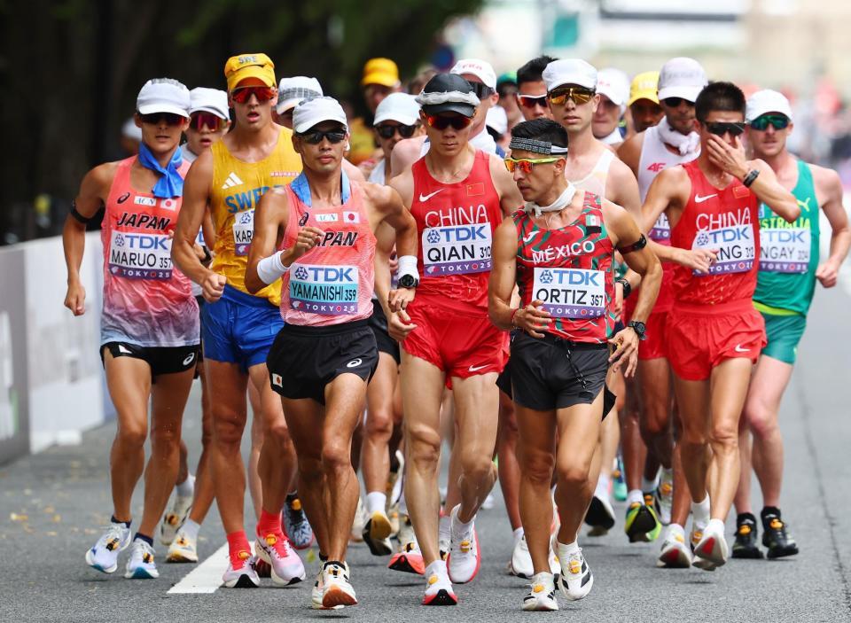 　懸命に歩く山西利和（手前左）