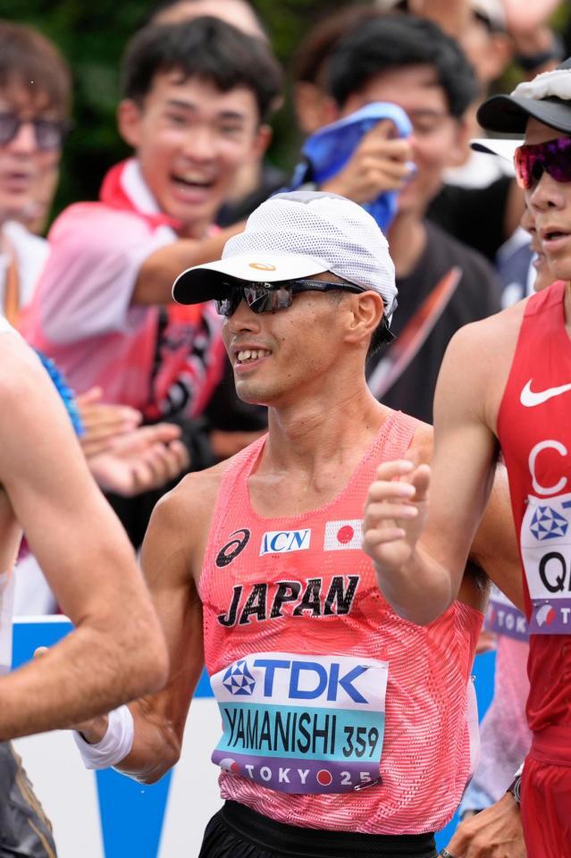 　沿道の声援を受け、笑顔を見せる山西利和