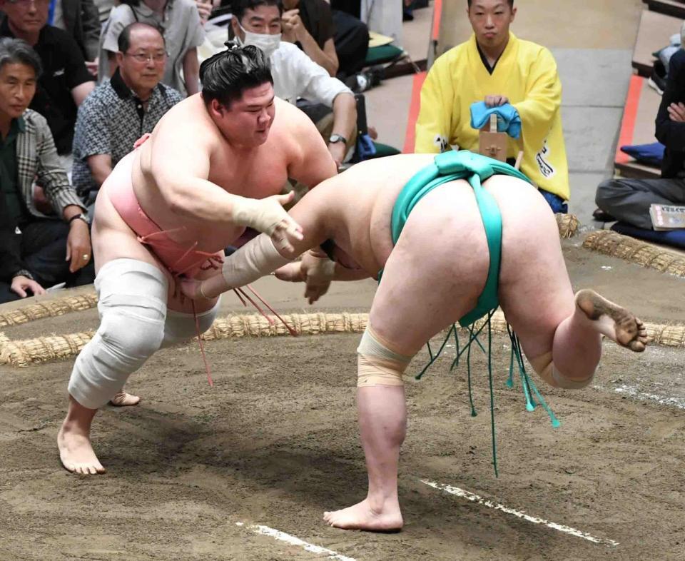 　一山本（右）をはたき込みで破り、１敗を守った宇良（撮影・佐藤厚）