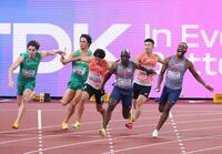 　第３走者の桐生祥秀からアンカーの鵜沢飛羽にバトンが渡る（中央）