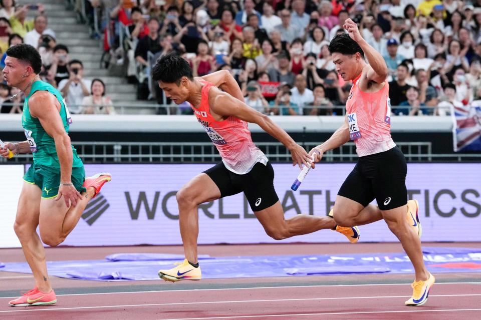 　第１走者の小池祐貴（右）からバトンを受け取る第２走者の柳田大輝