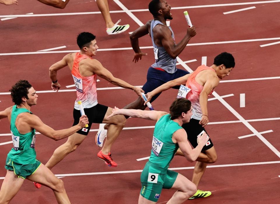 　男子４００メートルリレー予選　第３走者の桐生祥秀（中央左）からバトンを受け走り出すアンカーの鵜沢飛羽（同右）　