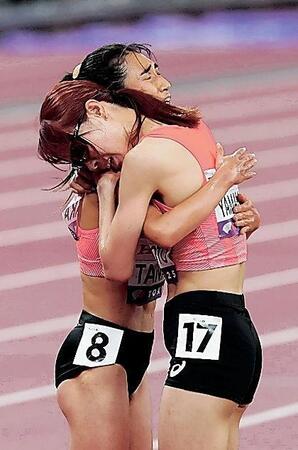 　女子５０００メートル予選を突破した田中希実（左）は山本有真と健闘をたたえ合う＝１８日