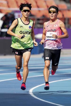 　パラ陸上世界選手権の男子５０００メートル（視覚障害Ｔ１１）で力走する唐沢剣也（右）＝ニューデリー（日本パラ陸連提供・共同）