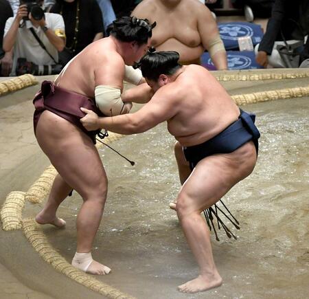 　錦富士（左）を寄り切りで破り、十両優勝を決めた朝白龍（撮影・佐藤厚）