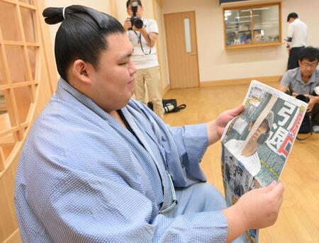 　阪神・原口文仁の引退を伝えるデイリースポーツを見つめる大の里（撮影・伊藤笙子）