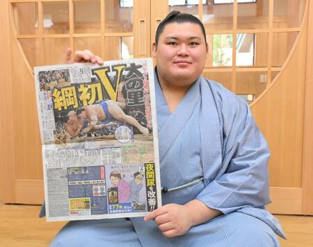 　優勝を伝えるデイリースポーツを手にする大の里（撮影・伊藤笙子）