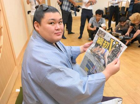 　優勝を伝えるデイリスポーツ本紙を手にする大の里（撮影・伊藤笙子）
