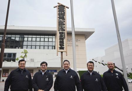 　大相撲九州場所の開催を知らせる「御免札」を設置した浅香山親方（中央）ら＝３日、福岡国際センター