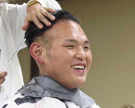 　笑顔で髪を整える湊川親方（撮影・石井剣太郎）