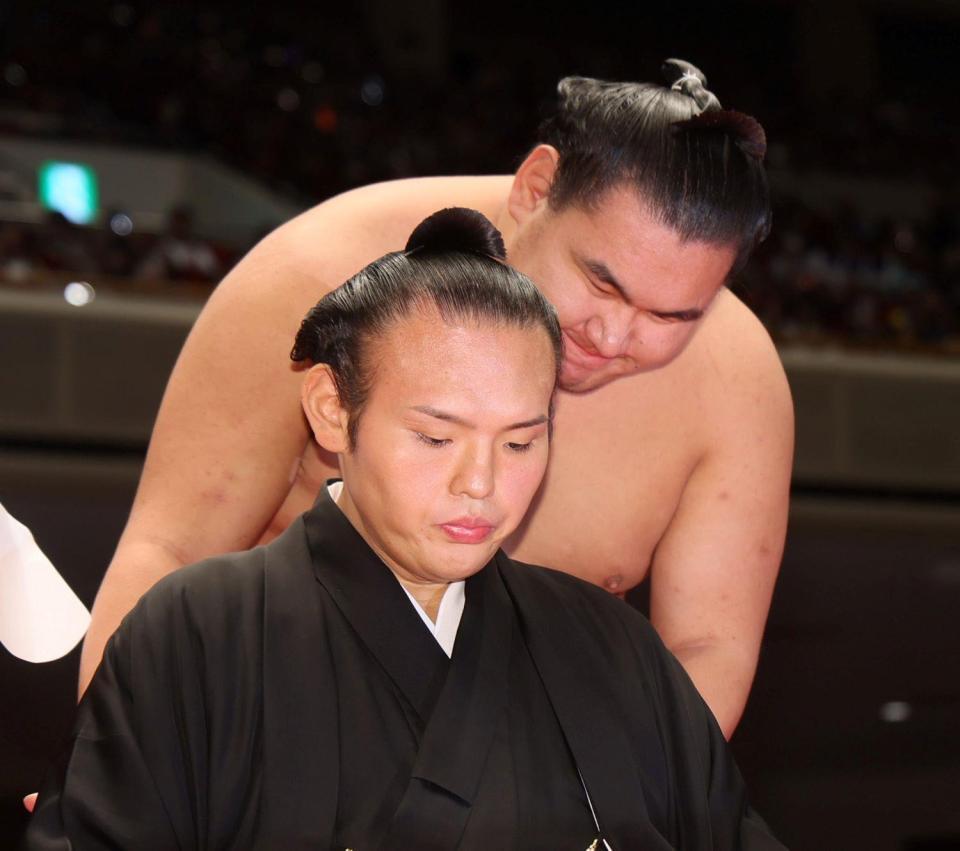 　豊昇龍（奥）からねぎらわれる湊川親方（撮影・石井剣太郎）