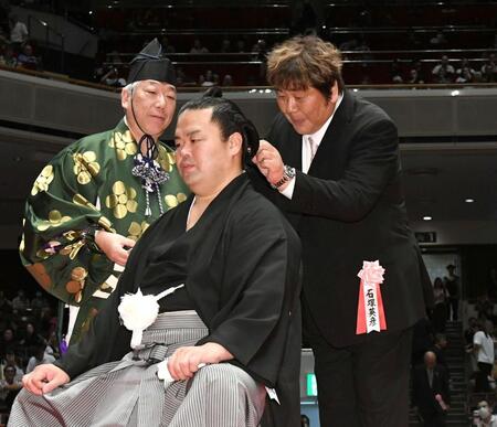 　はさみを入れる石塚英彦（右）＝撮影・佐藤厚