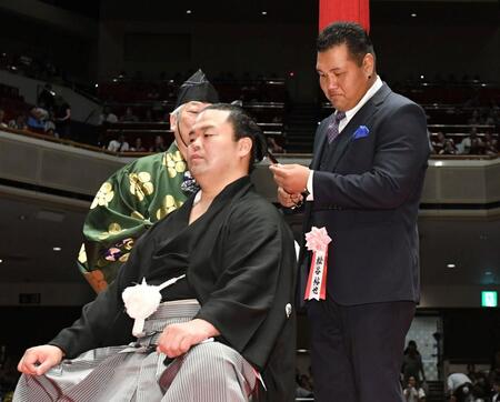 　はさみを入れる松谷裕也氏（元松鳳山）＝撮影・佐藤厚