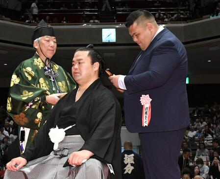 　はさみを入れる打越奎也氏（元阿武咲）＝撮影・佐藤厚