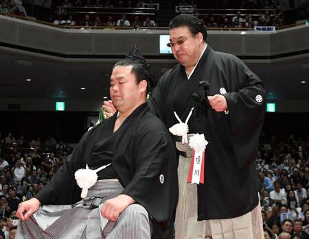 　止めばさみで妙義龍（左）のまげを切り落とし、肩をぽんとたたく境川親方（撮影・佐藤厚）