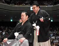 　止めばさみで妙義龍（左）のまげを切り落とし、肩をぽんとたたく境川親方（撮影・佐藤厚）