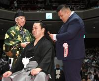 　はさみを入れる打越奎也氏（元阿武咲）＝撮影・佐藤厚