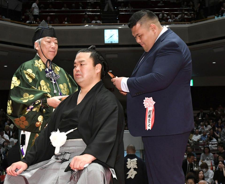 　はさみを入れる打越奎也氏（元阿武咲）＝撮影・佐藤厚