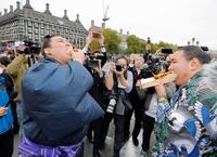 ロンドン市内でホットドッグを頰張る大の里（左）と豊昇龍の両横綱（共同）