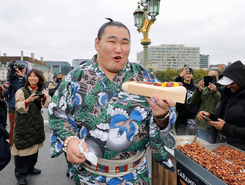 　ロンドン市内でホットドッグを手に笑顔を見せる豊昇龍＝14日