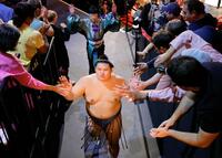 　大相撲ロンドン公演の閉会式を終え、観客とタッチを交わし引き揚げる横綱大の里（手前）＝共同