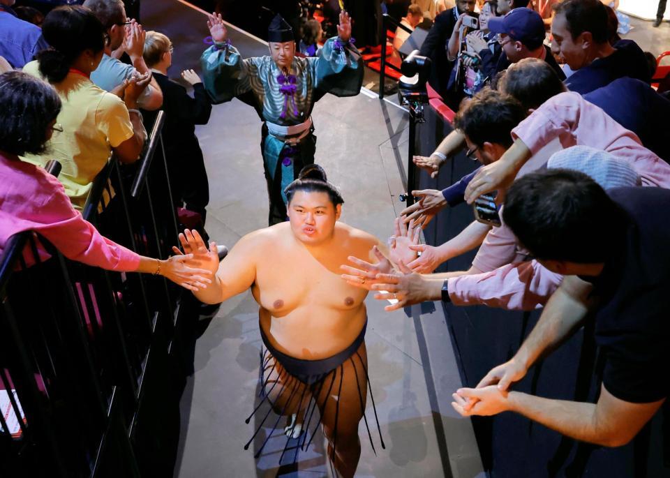 　大相撲ロンドン公演の閉会式を終え、観客とタッチを交わし引き揚げる横綱大の里（手前）＝共同