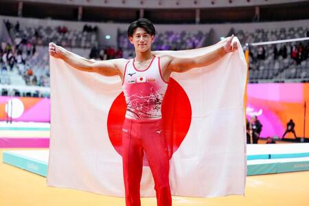 　体操の世界選手権男子個人総合で３連覇を果たし、日の丸を掲げる橋本大輝（共同）