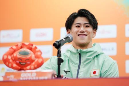 　体操の世界選手権男子個人総合で３連覇を果たし、記者会見で笑顔を見せる橋本大輝＝ジャカルタ（共同）