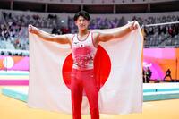 　体操の世界選手権男子個人総合で３連覇を果たし、日の丸を掲げる橋本大輝（共同）
