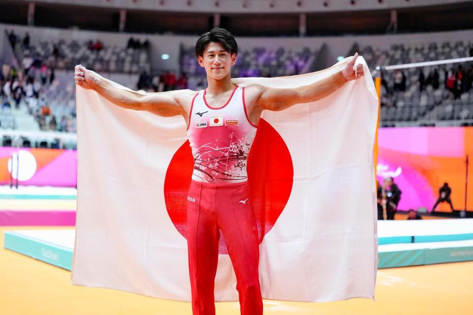 　体操の世界選手権男子個人総合で３連覇を果たし、日の丸を掲げる橋本大輝（共同）