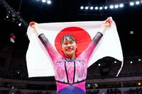 　世界選手権女子種目別の床運動で優勝し、日の丸を掲げる杉原愛子（共同）