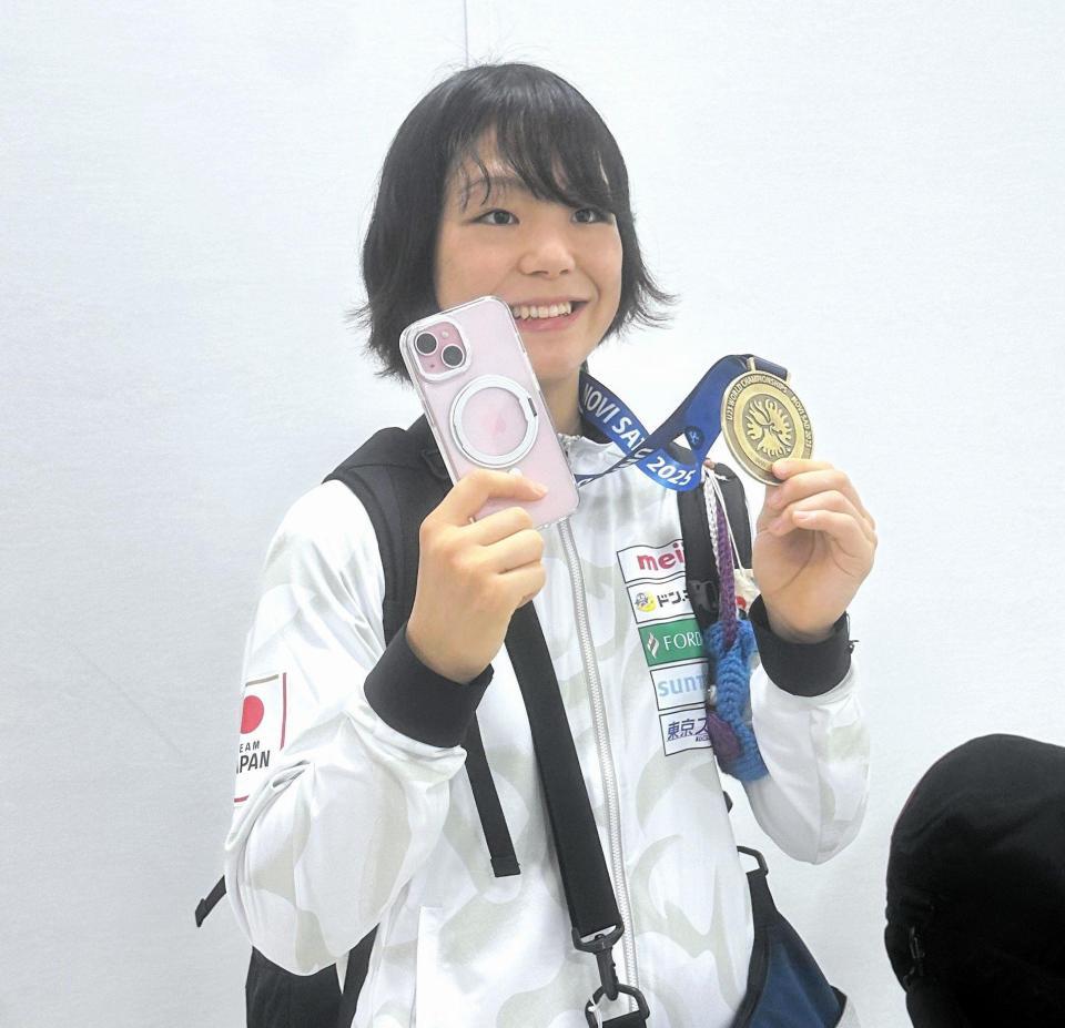 　Ｕ２３世界選手権の金メダルと、返ってきた携帯電話を手に笑顔を見せる藤波