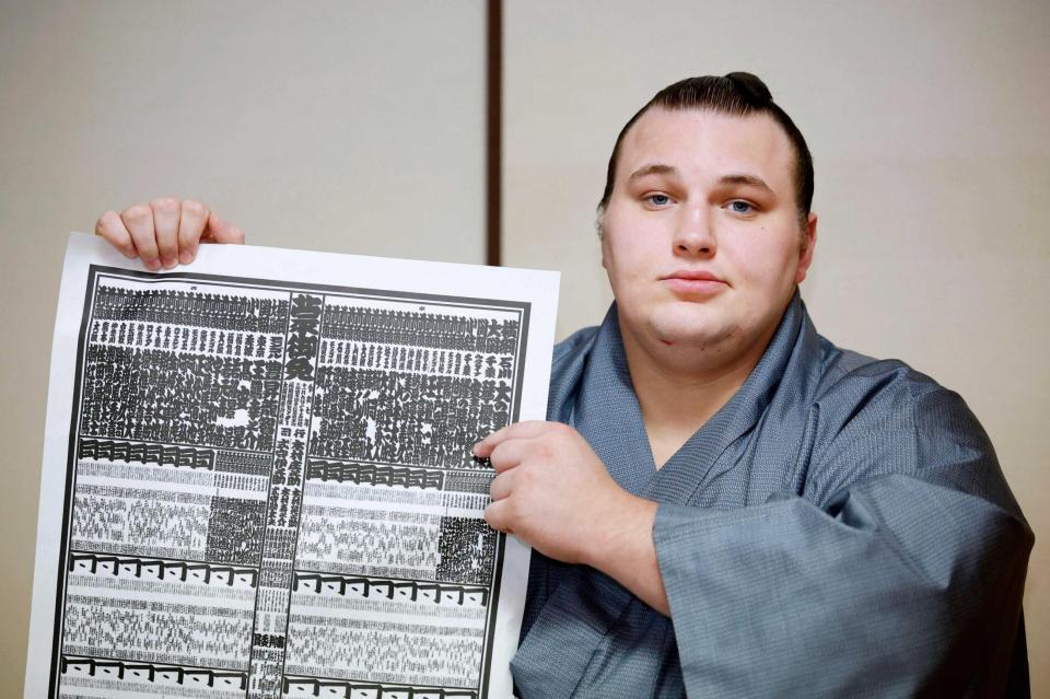 　大相撲九州場所の番付表を手にする新関脇の安青錦