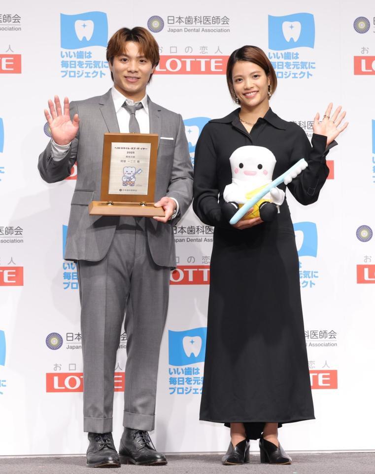 　ベストスマイル・オブ・ザ・イヤーを受賞し、手を振る阿部一二三（左）と阿部詩（撮影・西岡正）