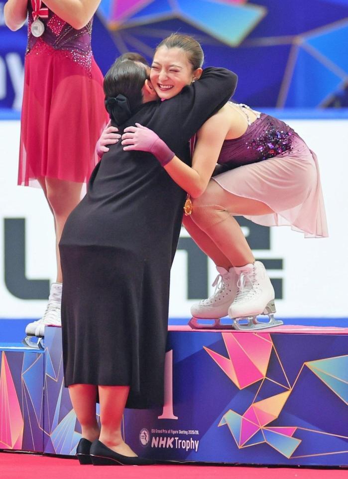 　伊藤みどりさん（左）からメダルを受け取り、抱き合う坂本花織