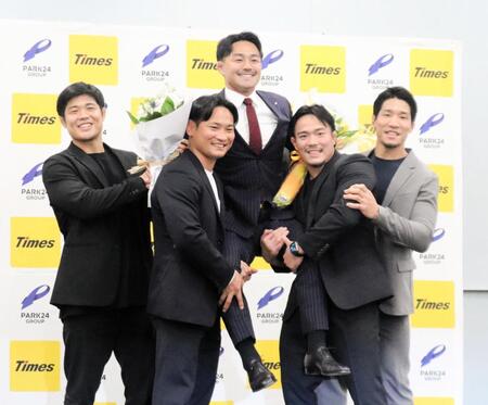　引退会見で後輩に担がれて笑顔を見せる橋本（中央）
