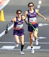 　４区の中島紗弥（右）からたすきを受け取るエディオンの細田あい