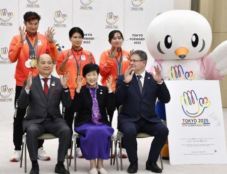 　記念撮影で、手をひらひらさせる手話の拍手を披露する国際ろう者スポーツ委員会（ＩＣＳＤ）のコーサ会長（前列右）と東京都の小池百合子知事（前列中央）ら＝２８日、東京都庁