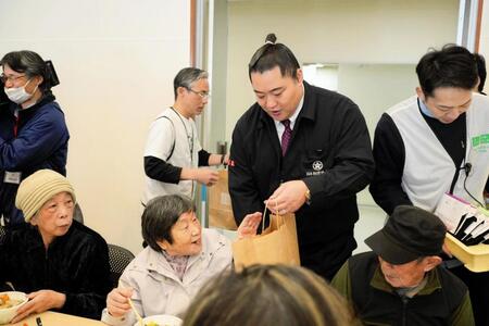 　被災者と交流する北陣親方（中央）＝提供写真