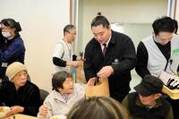 　被災者と交流する北陣親方（中央）＝提供写真