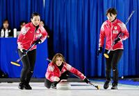 　ドイツ戦の第１エンド、ショットを放つ吉村。左は近江谷、右は小野寺（共同）