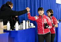 　ドイツに勝利し、小林（左）とタッチを交わす小谷。右は小野寺（共同）