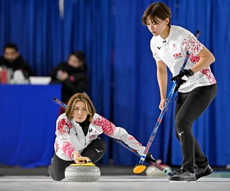 　トルコ戦の第５エンドでショットを放つ吉村。右は小野寺（共同）