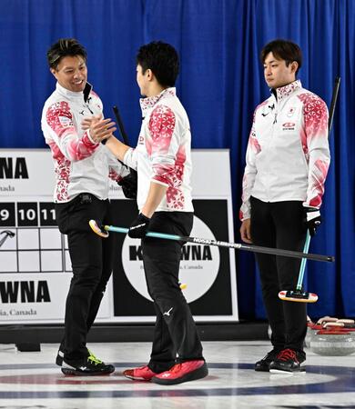 　男子１次Ｌで韓国に勝利し、山本（中央）とタッチを交わす山口。右は柳沢（共同）