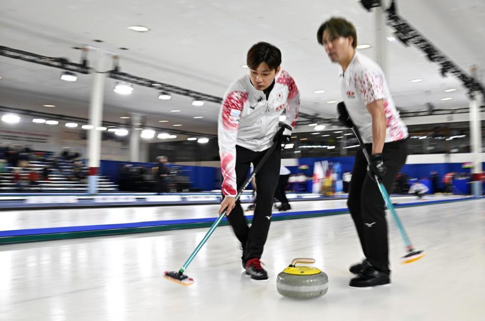 　韓国戦の第７エンド、スイープする柳沢。右は小泉（共同）