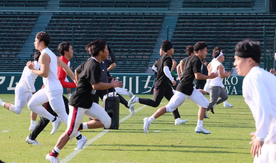 　ダッシュを繰り返してウオーミングアップをする立命大の選手たち（撮影・立川洋一郎）