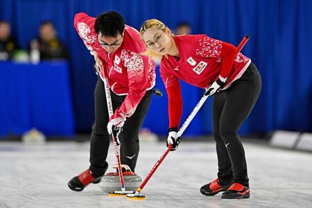 混合ダブルス１次Ｌ　ドイツ戦の第１エンド、スイープする小穴桃里（右）、青木豪組＝ケロウナ（共同）