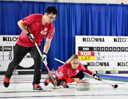 混合ダブルス１次Ｌ　ドイツ戦の第２エンド、ショットを放つ小穴桃里。左は青木豪＝ケロウナ（共同）